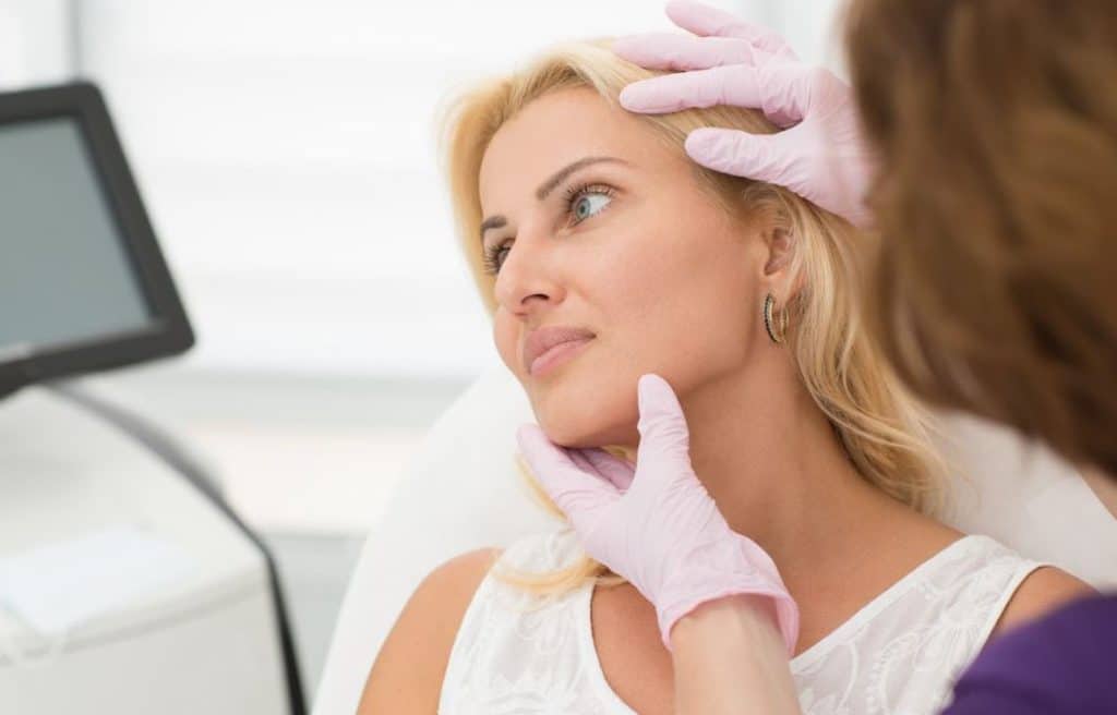 A doctor checking out a patients nose for surgery