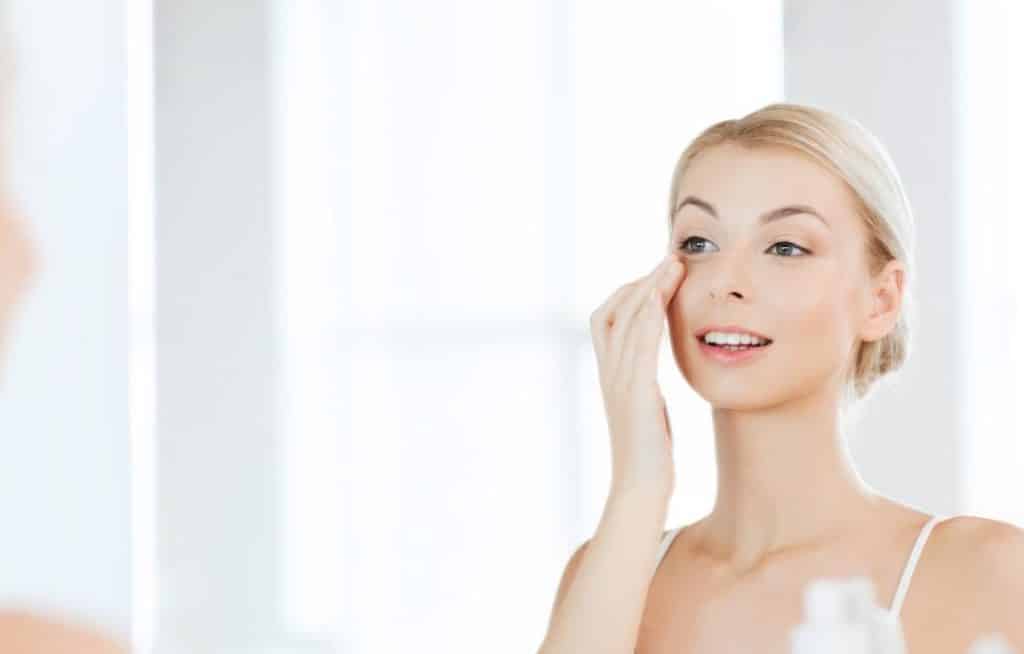 A woman applying an eye cream