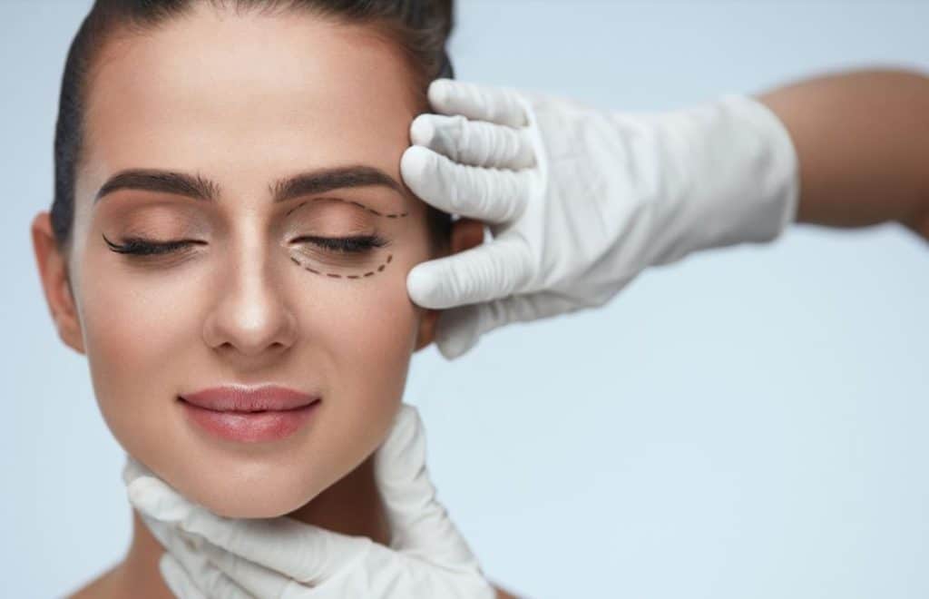 Plastic surgeon examining a womans face after blepharoplasty